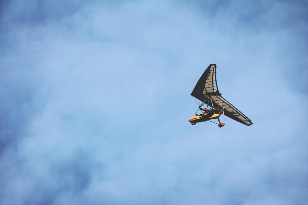 A light aircraft flies high in the blue sky, capturing a sense of adventure.